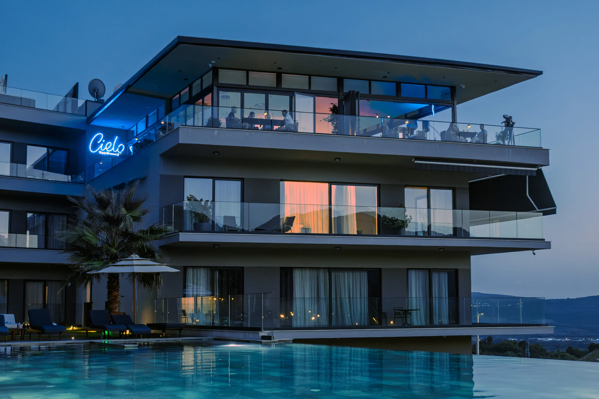 The illuminated Royal Blue exterior and pool with the Cielo sign above